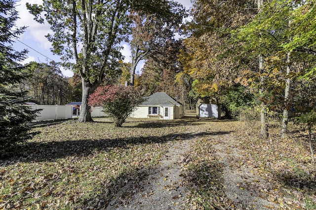 view of yard with fence and an outbuilding