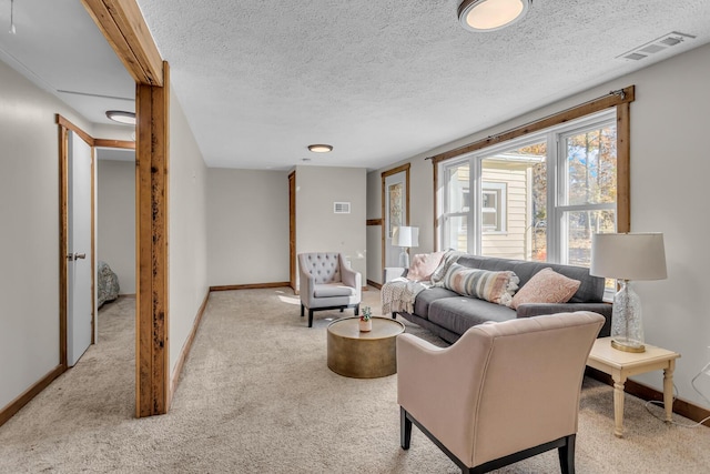 living room with baseboards, visible vents, a textured ceiling, and carpet flooring