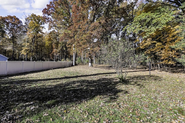 view of yard with fence and a view of trees