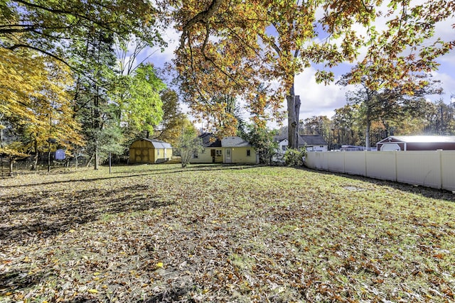 view of yard with an outbuilding, a shed, and fence