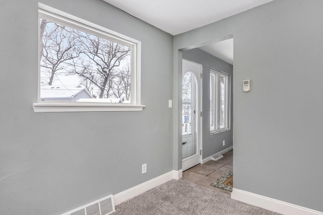 entryway with carpet, visible vents, and baseboards