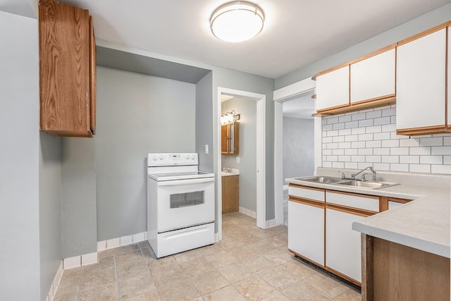 kitchen with a sink, white cabinetry, light countertops, white range with electric stovetop, and decorative backsplash