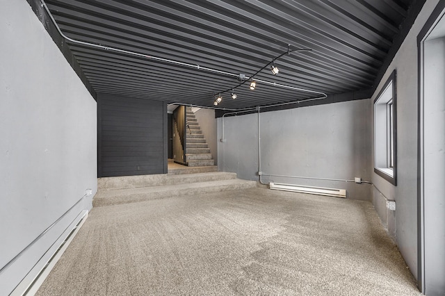 below grade area featuring carpet floors, stairs, and baseboard heating