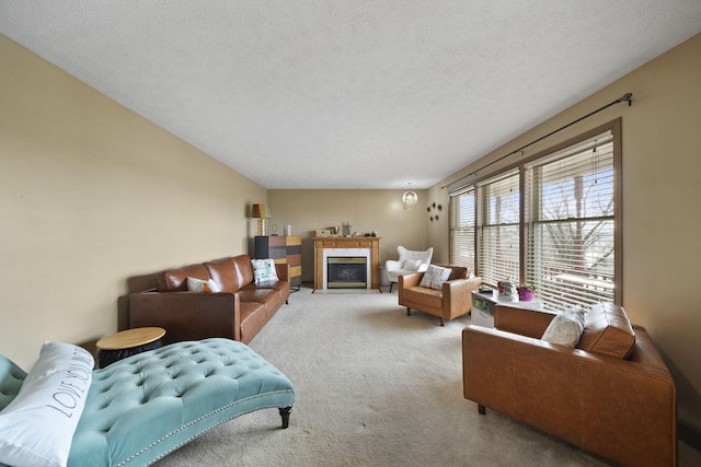 carpeted living room with a glass covered fireplace and a textured ceiling