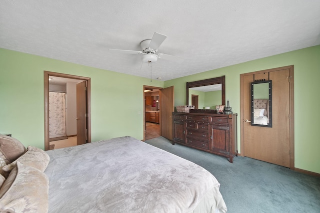 bedroom featuring ensuite bath, a textured ceiling, a ceiling fan, and carpet flooring