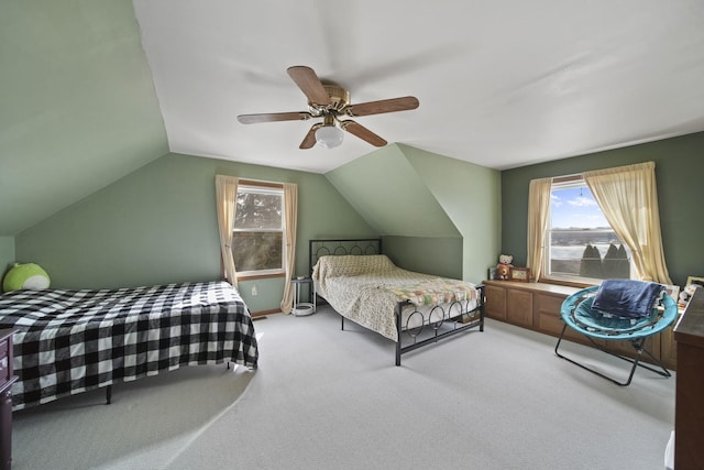 carpeted bedroom with ceiling fan and vaulted ceiling