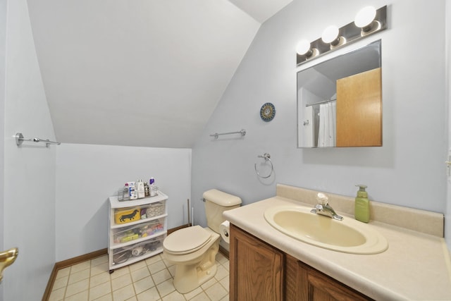 bathroom featuring lofted ceiling, toilet, vanity, baseboards, and tile patterned floors