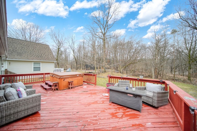 wooden deck with outdoor lounge area and a hot tub