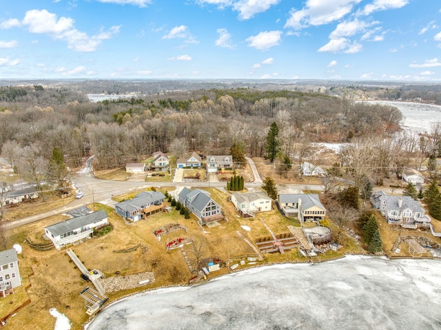 drone / aerial view with a wooded view and a residential view