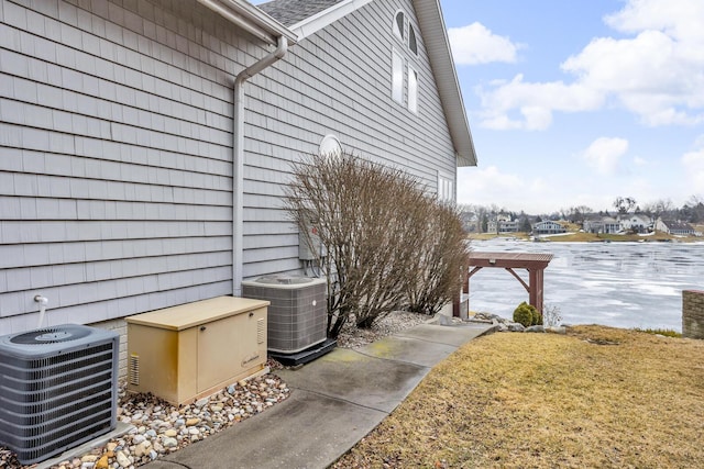 view of home's exterior with central AC and a yard