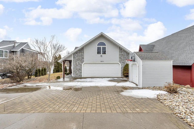 view of home's exterior featuring stone siding, decorative driveway, and an attached garage