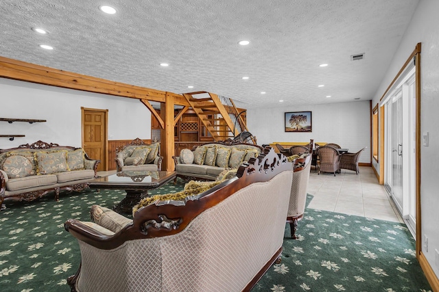 living area featuring a textured ceiling, recessed lighting, carpet floors, stairs, and tile patterned floors