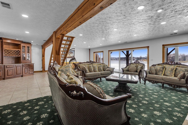 living room featuring a textured ceiling, light tile patterned flooring, visible vents, and recessed lighting