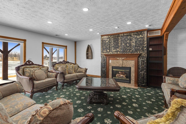 living room with visible vents, a tile fireplace, a textured ceiling, carpet flooring, and recessed lighting