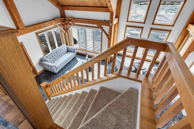 staircase featuring vaulted ceiling with beams