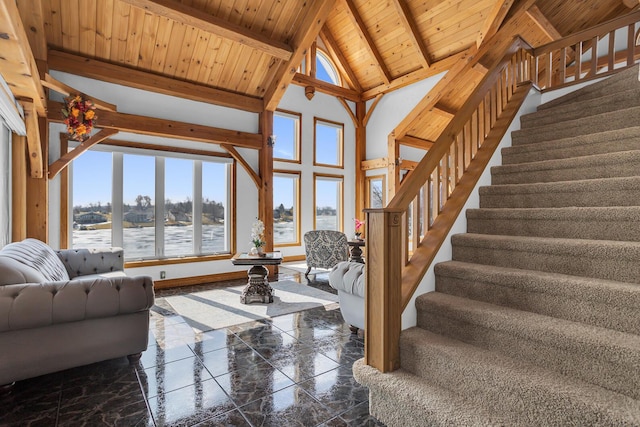 unfurnished living room with marble finish floor, beam ceiling, high vaulted ceiling, wooden ceiling, and stairs