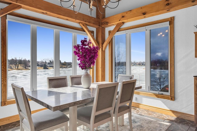 dining area featuring a chandelier and baseboards