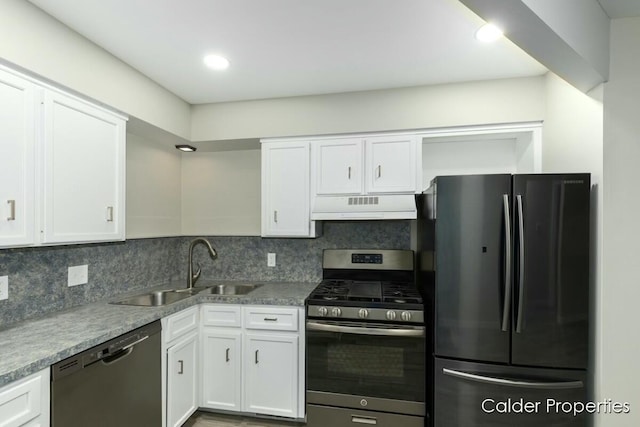 kitchen featuring stainless steel appliances, decorative backsplash, white cabinetry, a sink, and under cabinet range hood