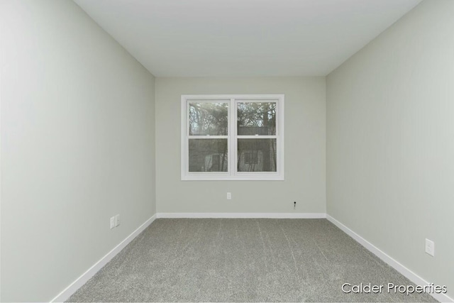 unfurnished room with carpet and baseboards