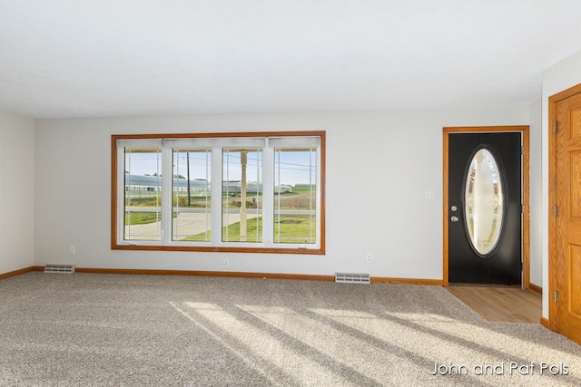 foyer featuring plenty of natural light, visible vents, and baseboards