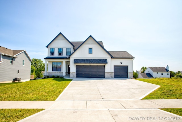 modern farmhouse featuring board and batten siding, a front yard, concrete driveway, and a shingled roof