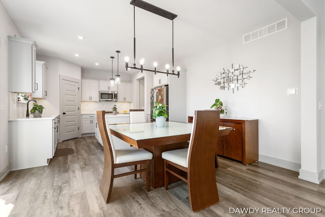 dining space with recessed lighting, visible vents, baseboards, and wood finished floors