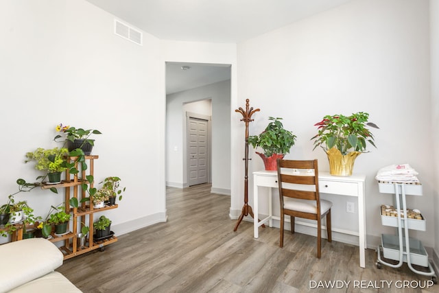 interior space with baseboards, visible vents, and wood finished floors