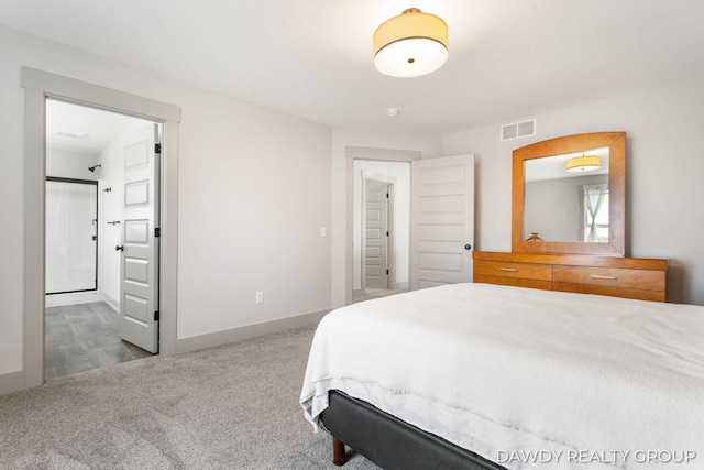 carpeted bedroom featuring ensuite bath, visible vents, and baseboards