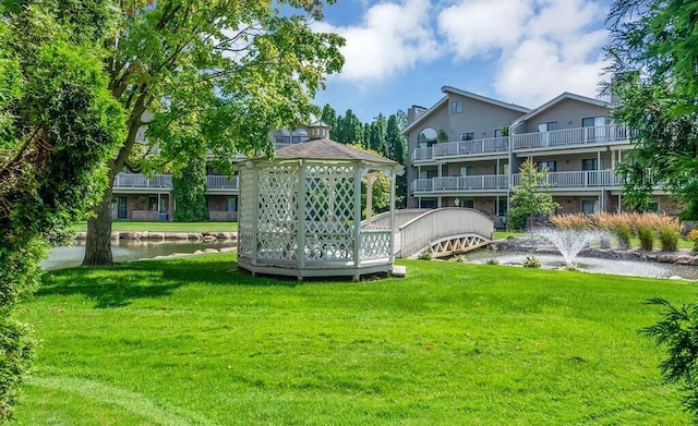 21082 Boulder Cir, Northville, MI 48167 - rear view of property featuring a lawn, a chimney, and a water view