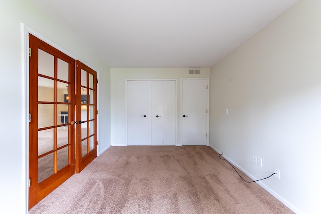 21082 Boulder Cir, Northville, MI 48167 - unfurnished bedroom featuring french doors, carpet flooring, baseboards, visible vents, and a closet