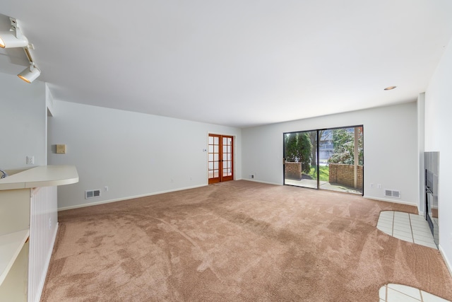 21082 Boulder Cir, Northville, MI 48167 - unfurnished living room with rail lighting, baseboards, visible vents, and carpet