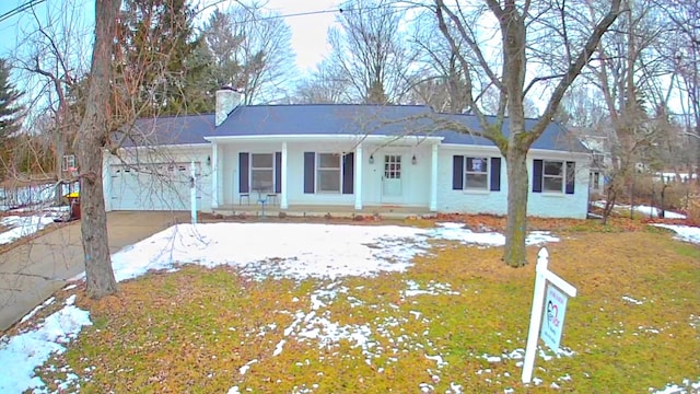 ranch-style house with driveway, a chimney, and an attached garage