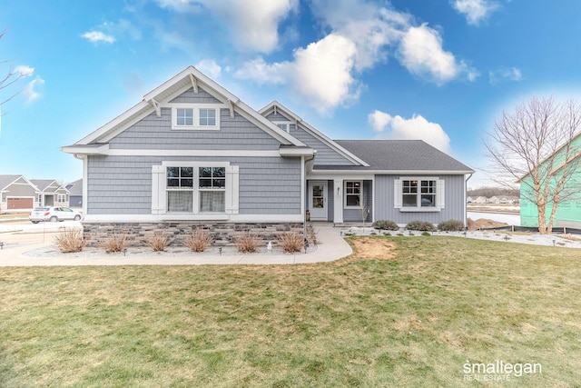 craftsman house featuring stone siding and a front lawn