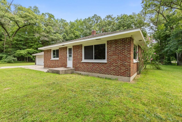 single story home featuring driveway, brick siding, a front lawn, and a chimney