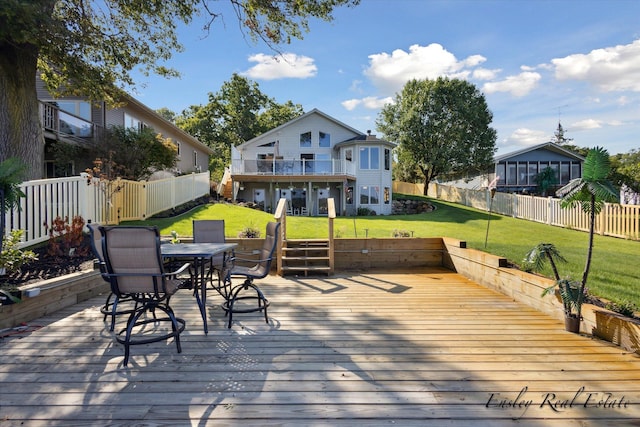 wooden terrace featuring fence private yard, outdoor dining area, and a lawn