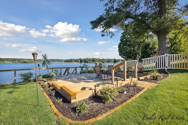 wooden terrace featuring a water view, fence, and a yard