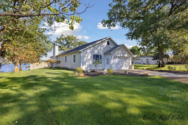 view of front facade featuring a garage, driveway, fence, and a front lawn