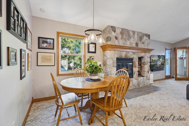 carpeted dining space with a fireplace and baseboards