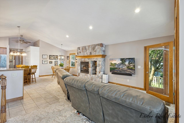 living area with lofted ceiling, light tile patterned floors, plenty of natural light, and a stone fireplace