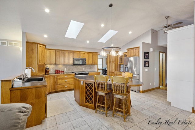 kitchen with decorative backsplash, a kitchen island, a breakfast bar area, stainless steel appliances, and a sink