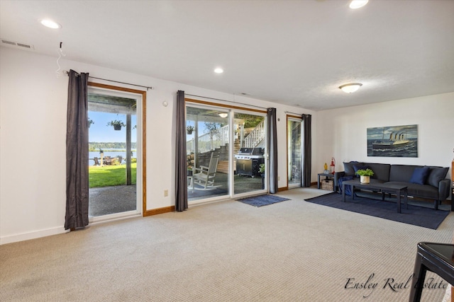 living area featuring carpet, visible vents, and baseboards