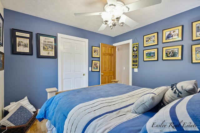 bedroom with a textured ceiling and a ceiling fan