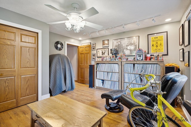 interior space featuring light wood-style flooring, baseboards, and ceiling fan