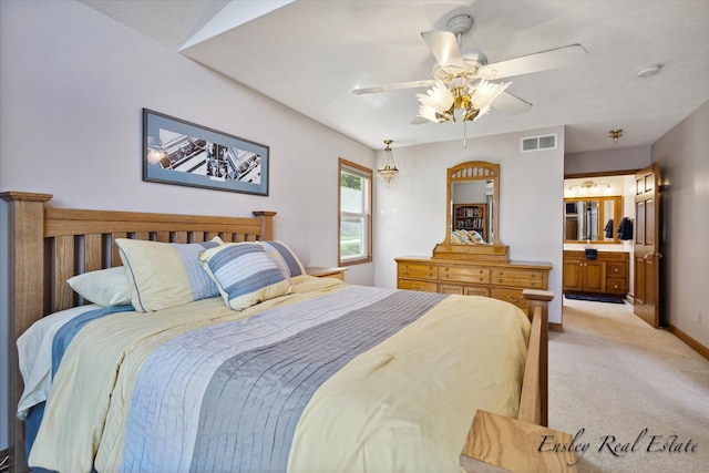 bedroom featuring ensuite bathroom, light colored carpet, a ceiling fan, baseboards, and visible vents