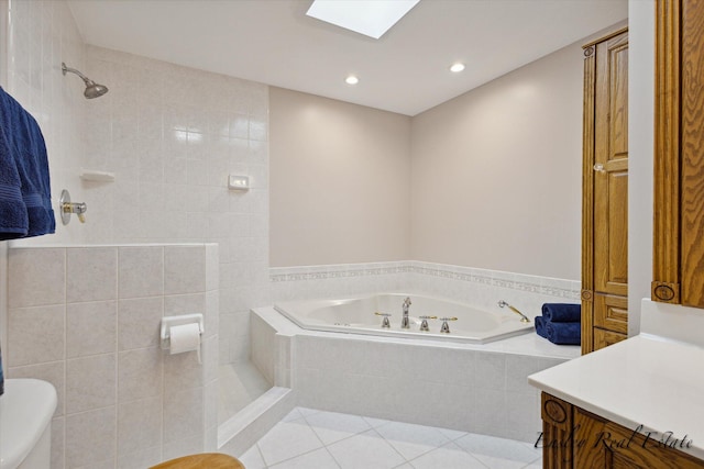 bathroom with a garden tub, toilet, a skylight, vanity, and tile patterned floors