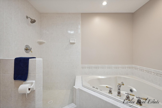 bathroom with recessed lighting, tiled shower, and a tub with jets