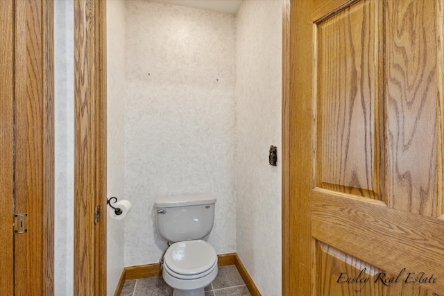 bathroom with tile patterned flooring, toilet, and baseboards