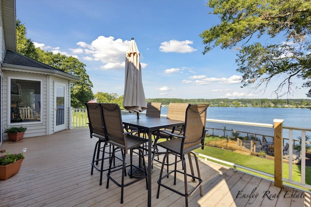 wooden terrace featuring outdoor dining area and a water view