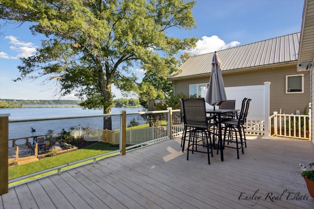 wooden deck featuring outdoor dining space and a water view