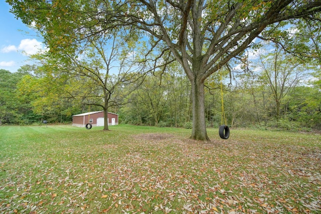 view of yard with an outbuilding and a forest view